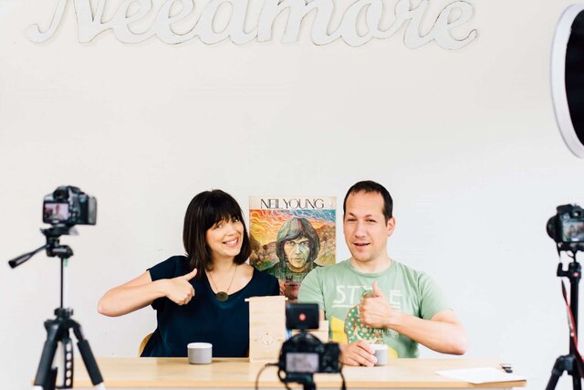 Kandace and Ray, hosts of Unpacking Coffee podcast, giving a thumbs-up