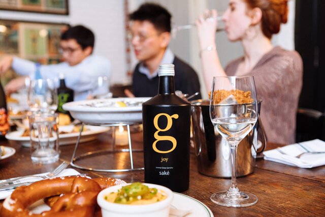 A scene from a SakéOne photoshoot at Woodsman Tavern featuring fried chicken and saké, a surprisingly delightful combination